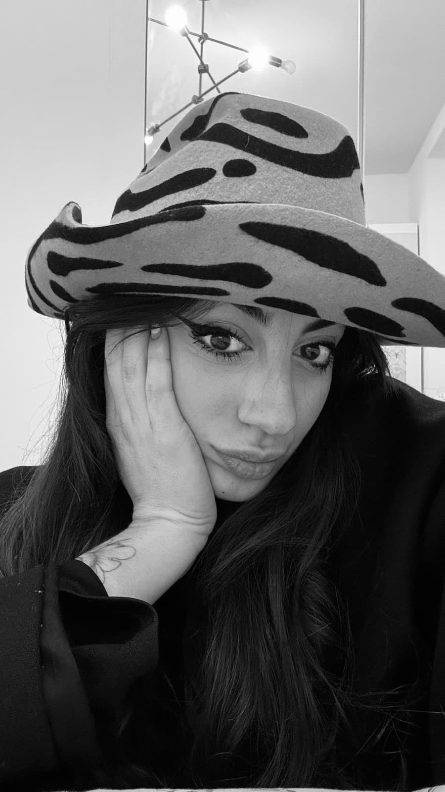 Michela Zanfini, in bianco e nero, con un cappello di feltro zebrato
